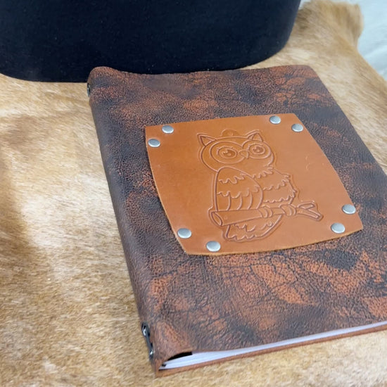 video shows flipping through owl leather journal to see lined blank paper pages